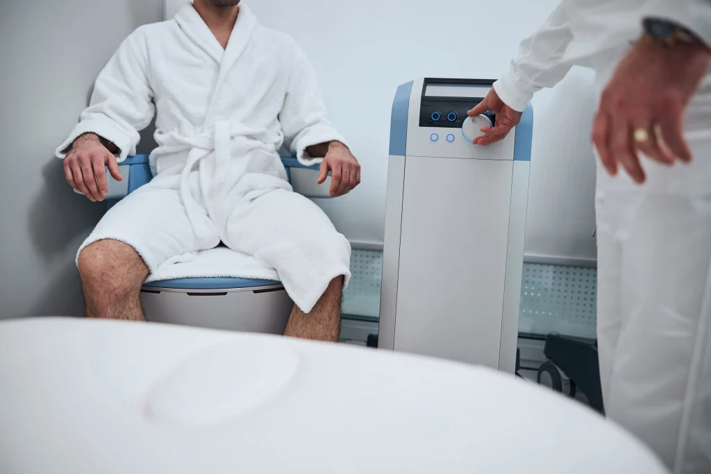 Man receiving a pelvic floor wellness treatment in a medical office